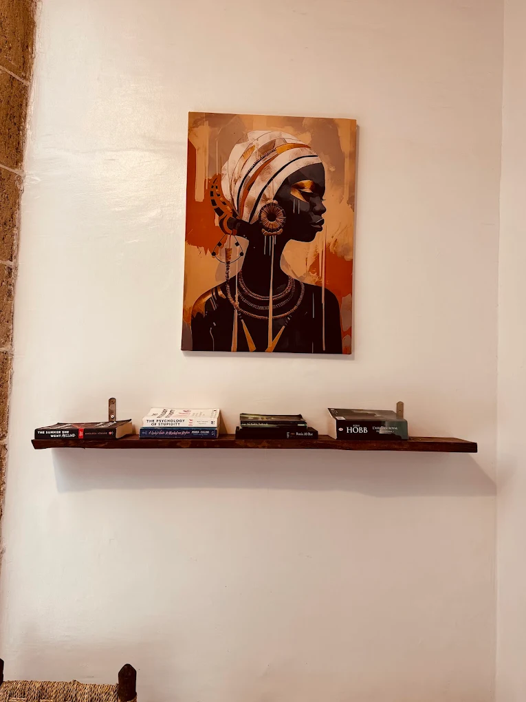 Salón acogedor con arte y estantería en un riad en Essaouira