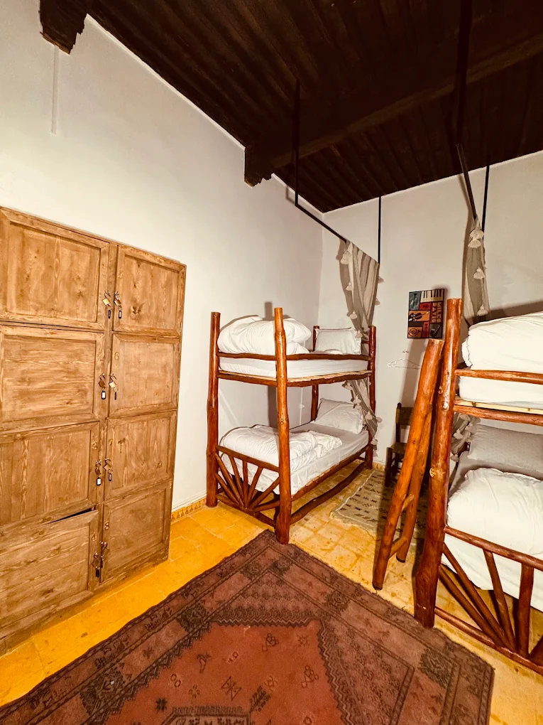 Dormitorio con literas de madera y taquillas — surf camp económico Essaouira