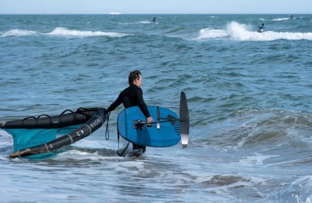 Rider de wingfoil sobre agua turquesa con ala moderna frente a Essaouira.