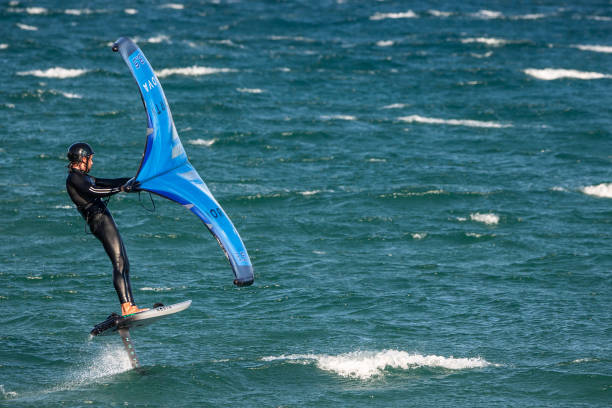 Clase de surf en la arena — instructor y alumnos en la playa.