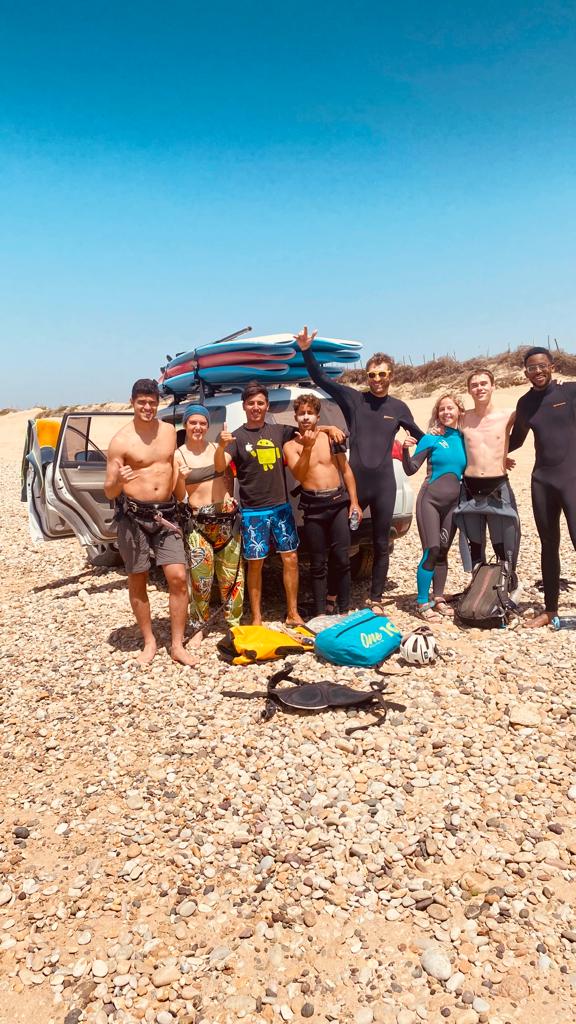 Grupo de surfistas frente al 4x4 en playa de guijarros — surf trip Essaouira