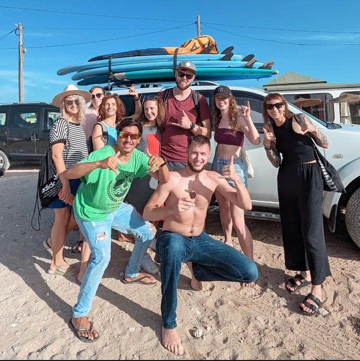 Foto de grupo con pick-up blanco y longboards en el techo — surf trip Marruecos